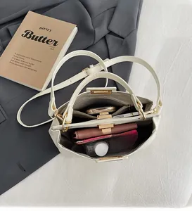 Interior view of white handbag showing spacious compartments with phone and wallet
