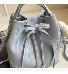 Detail der hellblauen Beuteltasche mit Kordelzugverschluss und Marmortextur