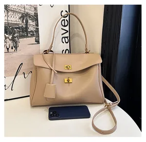 Detail view of beige lychee textured leather tote bag with gold lock and size comparison