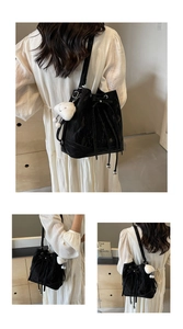 Detailansicht der schwarzen Lackleder-Beuteltasche mit Kordelzug und weichem Plüsch-Anhänger