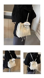 Detail der cremefarbenen Beuteltasche mit weicher Textur und Wolken-Anhänger