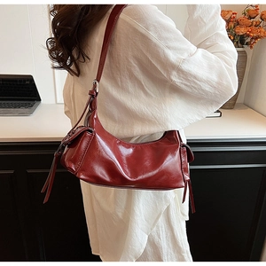 Details der dunkelroten Vintage Ledertasche mit Seitentaschen und silbernen Metallteilen