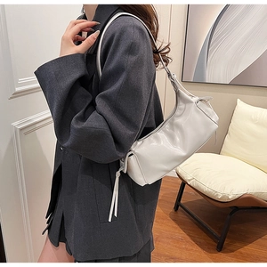 Off-white glossy leather shoulder bag featuring long fringe details and zip closure