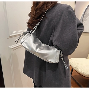 Silver metallic rectangular shoulder bag with side drawstring detail shown on a model