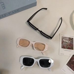Detailed top view of retro square chunky sunglasses in black, cream and white finishes