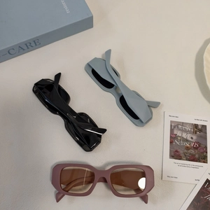 Flat lay of wide rectangular sunglasses in black, light blue, and matte dusty rose colors