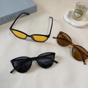 Détail de lunettes de soleil œil de chat pour enfants en noir et ambre sur un bureau