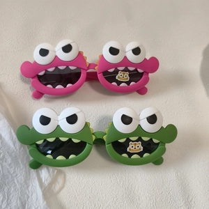 Detail of pink and green silicone sunglasses with big eye monster frames for children