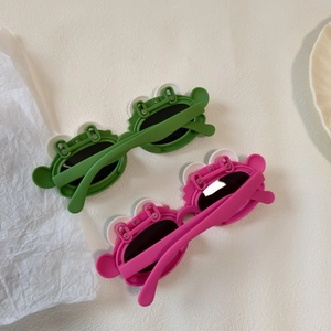 Detail shot of cute frog-shaped polarized kids sunglasses in green and pink colors