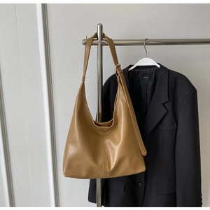 Détails du sac hobo caramel montrant la texture du cuir plissé et la bandoulière réglable