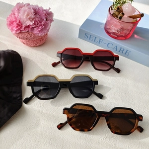 Three retro hexagonal sunglasses in red, black-gold and tortoiseshell with gradient lenses