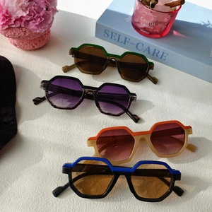 Macro display of multi-colored geometric polygon sunglasses on a stylish tabletop