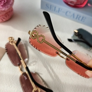 Detail of rimless gradient sunglasses with gold hollow geometric key design temples