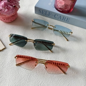 Close-up of rimless gradient sunglasses with gold metal gears and rivets decoration