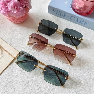 Three pairs of rimless cat-eye sunglasses with gold metal temples and gradient lenses
