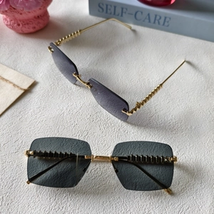 Detail of rimless cat-eye sunglasses with purple gradient lenses and metal rivet accents