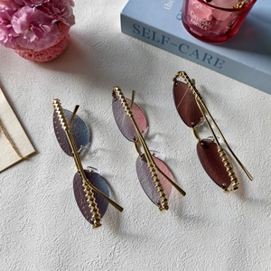 Détail de lunettes œil de chat sans monture avec verres dégradés et branches dorées