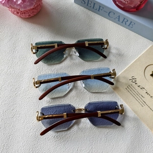 Detail of rimless sunglasses with gradient lenses and wood grain temples in a lifestyle set
