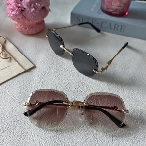 Detail showing rimless sunglasses with diamond-cut lenses and sleek gold metal temples