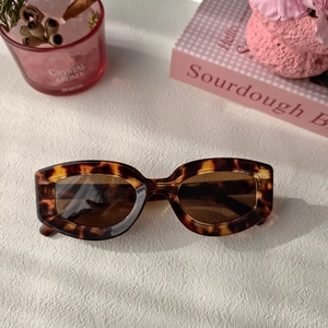 Vue à plat de lunettes de soleil rétro en écaille avec verres bruns sur blanc