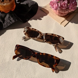 Détail de lunettes de soleil rectangulaires rétro léopard et écaille sur surface texturée