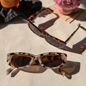 Vue détaillée de lunettes de soleil rectangulaires en écaille et beige avec ombres d'art