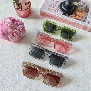 Sélection de quatre lunettes de soleil carrées en cristal sur une table en marbre