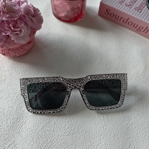 Vue détaillée de lunettes carrées avec cristaux brillants sur monture gris foncé