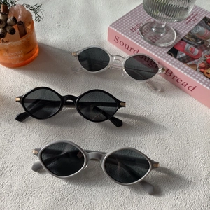 Retro oval resin sunglasses in transparent, black, and gray with golden temple accents