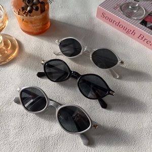 Detailed top view of three retro oval sunglasses with gold metal hinges on white background