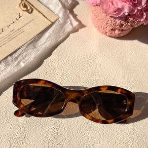 Close-up of retro tortoiseshell sunglasses with dark lenses on a stylish artistic background
