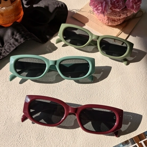 Vue détaillée de lunettes de soleil vintage rectangulaires en olive, rouge et vert sauge