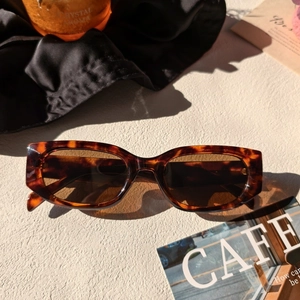 Gros plan sur des lunettes de soleil carrées vintage écaillées avec verres marron foncé