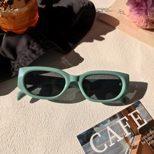 Vue détaillée de lunettes de soleil rétro en résine vert clair avec verres foncés
