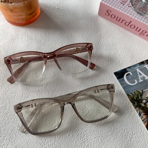 Détail de deux montures de lunettes carrées en résine marron dégradé et gris clair