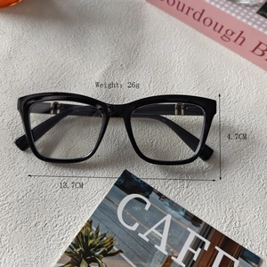 Lunettes carrées classiques noires en résine avec accents métalliques dorés en U