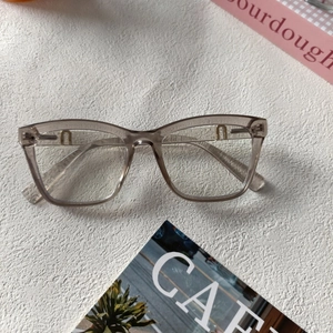 Lunettes vintage carrées couleur thé avec détail métallique en U doré sur fond blanc