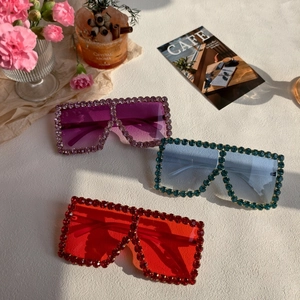 Detail view of colorful rhinestones on oversized square sunglasses with gradient lenses