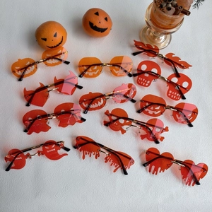Multiple unique Halloween resin sunglasses with skull and pumpkin designs on marble
