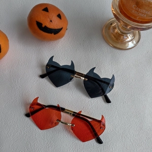 Macro detail of devil heart sunglasses with gold metal temples for Halloween parties