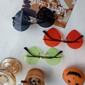 Three rimless heart-shaped sunglasses with engraved expressions and golden metal frames