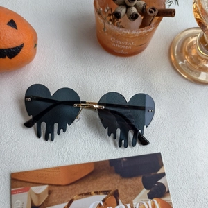 Close-up of melting heart sunglasses with gold frame and Halloween prop setting