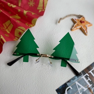 Détail des lunettes de soleil sans monture en forme de sapin de Noël avec verres verts