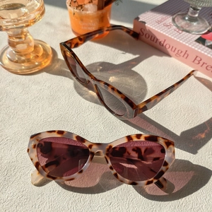 Détail macro de deux lunettes de soleil œil-de-chat rétro avec motifs d'écailles de tortue