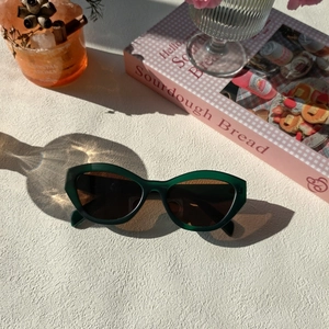 Gros plan de lunettes de soleil œil-de-chat vert émeraude avec verres foncés