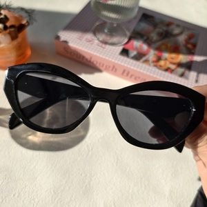 Gros plan de lunettes de soleil œil de chat noires avec monture en résine et décors
