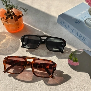 Détail de lunettes de soleil carrées à double pont en acétate noir et écaille