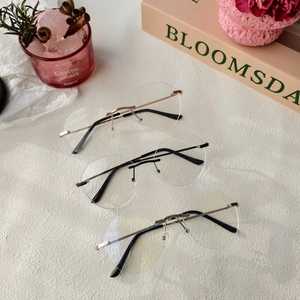 Vue détaillée de lunettes ovales sans monture avec trois coloris de branches métalliques