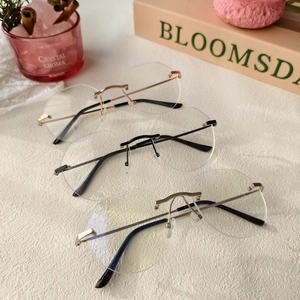 Trois paires de lunettes ovales sans monture en métal or rose, noir et argent