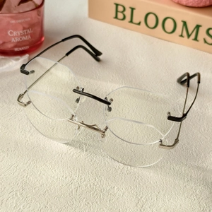Gros plan de lunettes ovales sans monture noires et argentées avec branches en métal